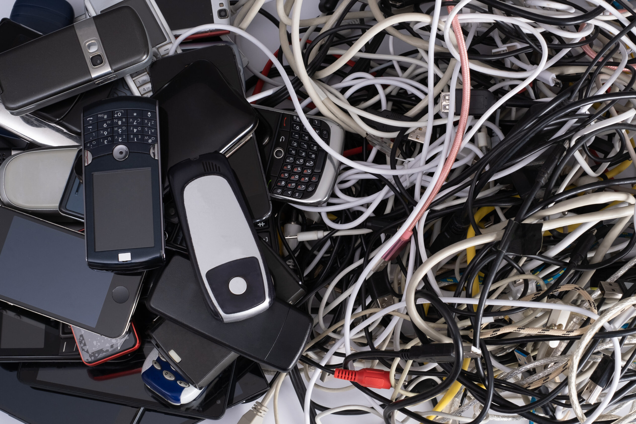 Pile of tangled old smart technology wires, charging cables and used obsolete mobile phones. Old electronic devices. The concept of recycling and disposal of electronic waste. Why Wireless Mesh Networks are Outdated and Belong in the Past